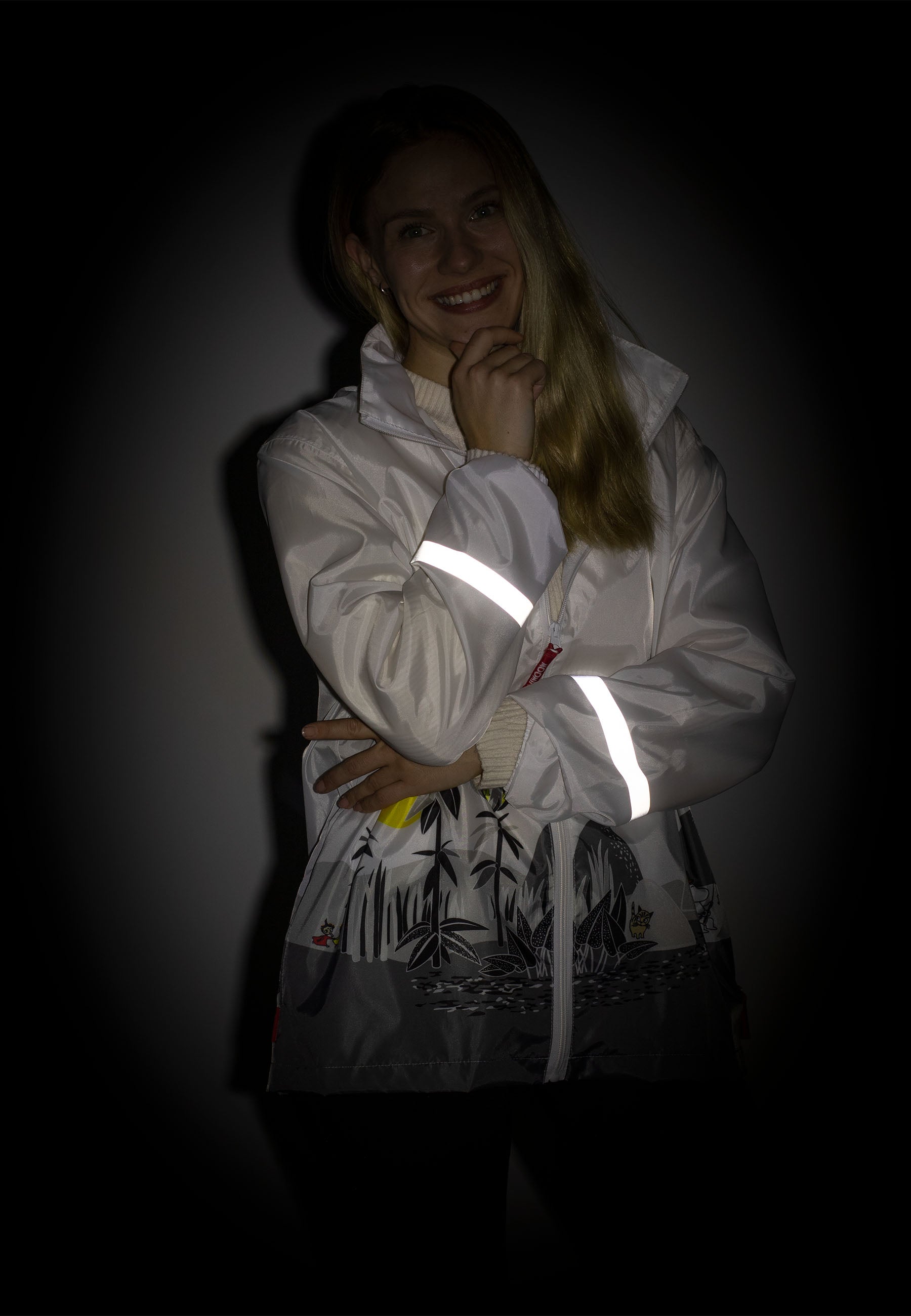 Lasessorin Muumi Saaressa sadetakki heijastavilla yksityiskohdilla pimeässä